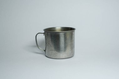 Gri arkaplanda izole edilmiş gümüş metal paslanmaz çelik bardak..