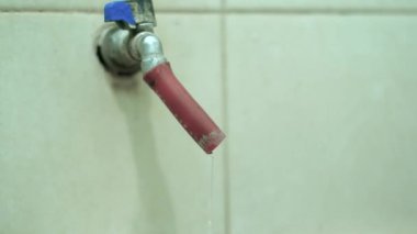 Banyoda su olan kırmızı beyaz bir plastik şişe.