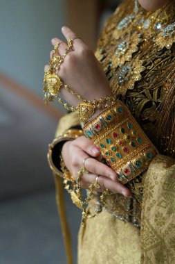 Parmağında altın takılar olan güzel bir kadına yaklaş.