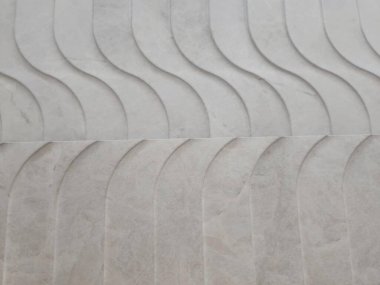 Eğimli ve dalgalı dokuları olan mermer yüzey soyut ve zarif bir üç boyutlu etki yaratıyor. Şablon akan suyu taklit ederek mimari elementlere karmaşıklık katıyor..