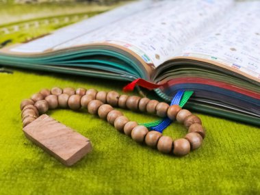 Yeşil bir paspasın üzerinde Kuran-ı Kerim.