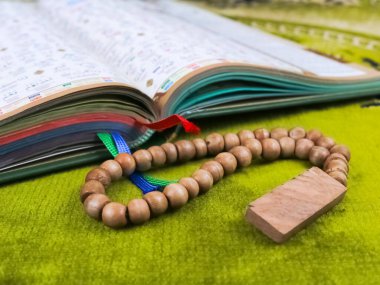 Yeşil bir paspasın üzerinde Kuran-ı Kerim.