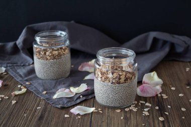 Chia tohumları ve granola, gri arka planda cam bir kavanozda chia tohumları. sağlıklı kahvaltı.
