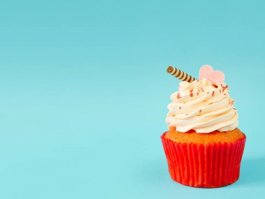 Kopya alanı ile mavi arka plan üzerinde buzlanma buttercream ile cupcake
