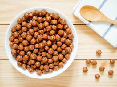 Ahşap arka plan üzerine bir kase çikolata Mısır gevreği topları. Sağlıklı kahvaltı kavramı. Üstten Görünüm.