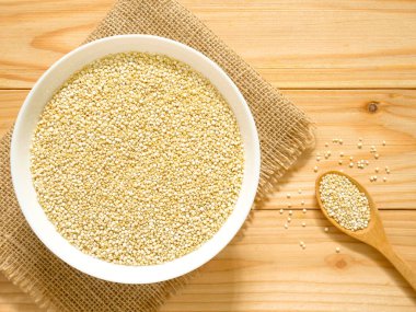 Bir kase çiğ beyaz Quinoa ahşap masa üzerinde. Üstten görünüm.