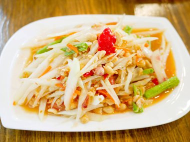 Tay yeşil papaya salatası (som tam veya som tum) ahşap masa üzerinde. Tayland gıda