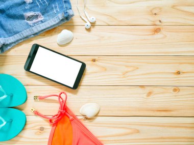 Ahşap arka planda kadın giysisi ve aksesuarları. Plaj kıyafeti konsepti