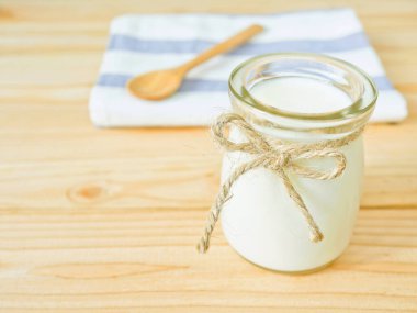 Sade yoğurt ahşap tablo kopya alanı bir kavanoz. Sağlıklı gıda kavramı.