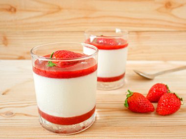 Çilekli panna cotta ve ahşap masada taze çilek. İtalyan tatlısı.