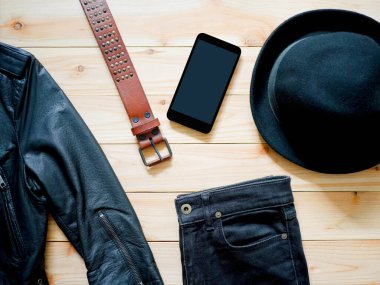 Klasik siyah deri ceket, kemer, kot pantolon, cep telefonu ve ahşap fötr şapka. Üst görünüm. 