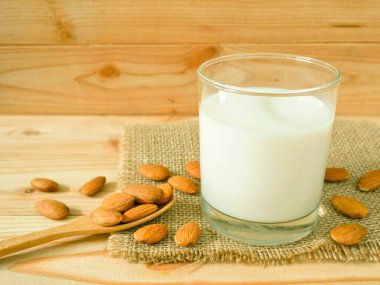 Ahşap masa üzerinde kabuklu badem ile badem süt