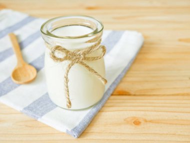 Sade yoğurt ahşap tablo kopya alanı bir kavanoz. Sağlıklı gıda kavramı.