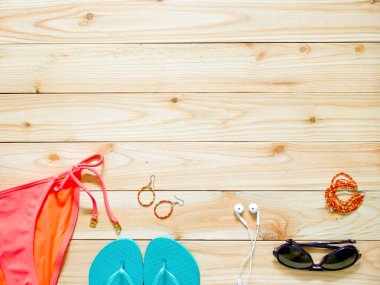 Ahşap arka planda kadın giysisi ve aksesuarları. Plaj kıyafeti konsepti. Boşluğu kopyala.