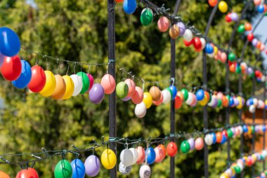 Renkli paskalya yumurtalarıyla süslenmiş kemerli metal çerçeve.