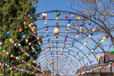 Renkli paskalya yumurtalarıyla süslenmiş kemerli metal çerçeve.