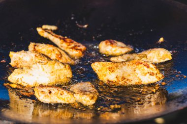 Izgara et dilimleri, açık havada sıcak yağda kızartılıyor.