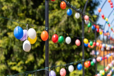 Renkli paskalya yumurtalarıyla süslenmiş kemerli metal çerçeve.