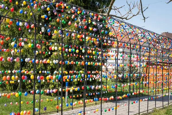 Renkli paskalya yumurtalarıyla süslenmiş kemerli metal çerçeve.