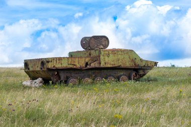 Rusty old soviet military vehicle wreck in a field clipart