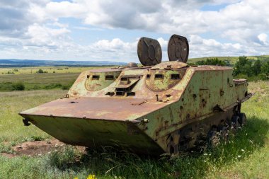 Rusty old soviet military vehicle wreck in a field clipart