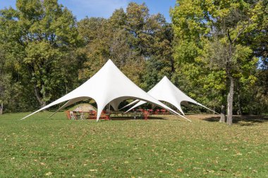 Parkta renkli sandalyeli açık hava çadırı