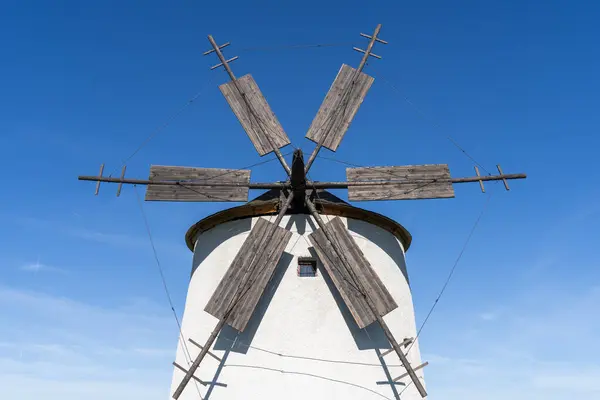 Arka planda mavi gökyüzü olan taştan yel değirmeni.