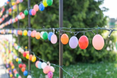 Renkli paskalya yumurtalarıyla süslenmiş kemerli metal çerçeve.