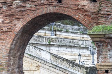 Tarihsel tuğlalar, arka planda Bologna 'daki taş merdiven eviyle kemerli eski kapılar.