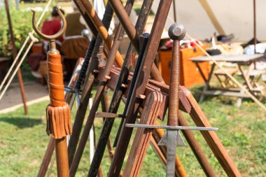 Ortaçağ kılıçları canlandırma olayında ahşap raflarda sergilenir.