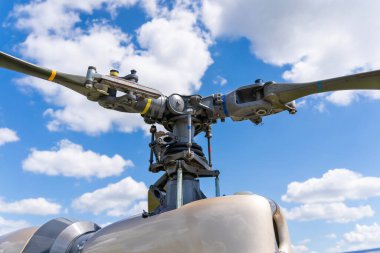 Arka planda mavi bulutlu gökyüzü olan askeri helikopter ana rotoru