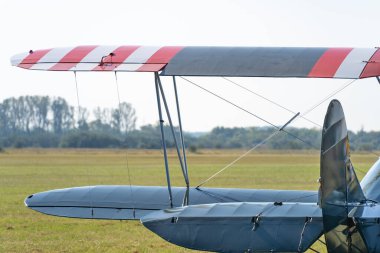Arka planda çim pist olan eski bir çift kanatlı uçağın kanatları