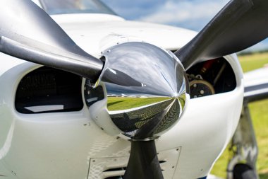 Gri küçük bir uçağın dört çatallı pervanesi, kafa kafaya.