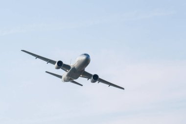 Mavi gökyüzünde uçan gri askeri A319 nakliye uçağı