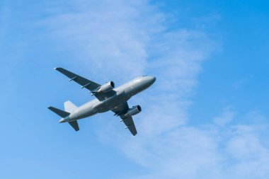 Mavi gökyüzünde uçan gri askeri A319 nakliye uçağı