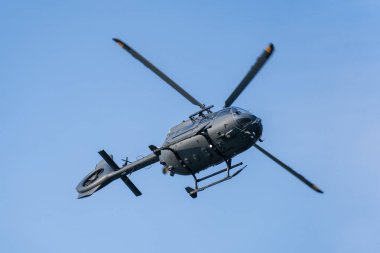 Macaristan 'da mavi gökyüzünde uçan modern askeri H145M nakliye helikopteri