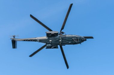 Macaristan 'da mavi gökyüzünde uçan modern askeri nakliye helikopteri