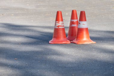 Gri asfaltta 3 turuncu sinyal şamandırası