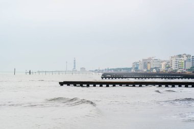 Sonbaharda Jesolo, İtalya 'da rıhtımlı deniz manzarası ve yumuşak dalgalar