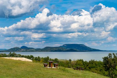 Arkasında volkanik dağlar ve bulutlar olan yaz Balaton manzarası
