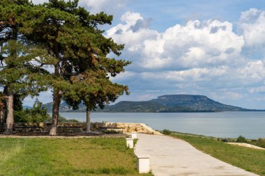 Arkasında volkanik dağlar ve bulutlar olan yaz Balaton manzarası