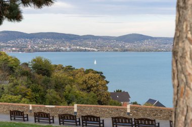 Sonbahar güneşinde Balaton Gölü 'nde bir yelkenli gemi. Arka planda Balatonfued var.