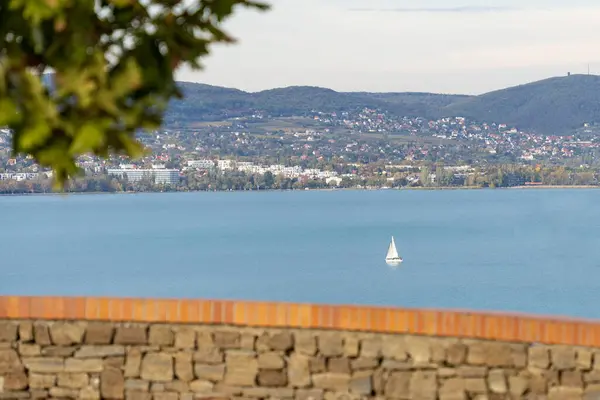 Sonbahar güneşinde Balaton Gölü 'nde bir yelkenli gemi. Arka planda Balatonfred var.