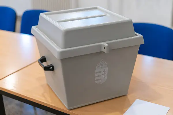 Macar devlet arması ve oy zarfıyla dolu bir oy sandığı.