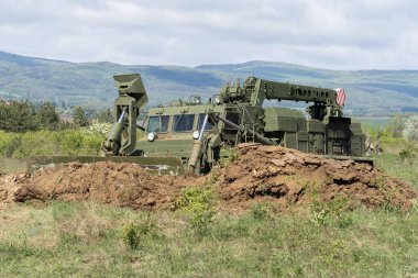 Vinç ve buldozer bıçaklı yeşil askeri mühendislik aracı