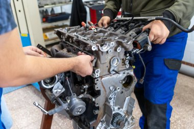 Otomatik mekanik bir atölyede parçalanmış bir araba motoru monte ediyor