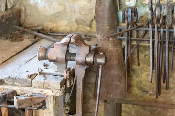 Demirci dükkanında eski demir mengene ve geleneksel demirci aletleri.