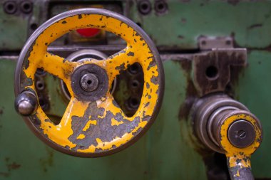 Eski yeşil yıpranmış değirmen kontrol düğmeleri ve kontrol kadranları bir atölyede