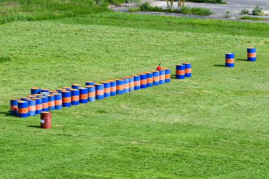Mavi kırmızı yağ varilleri yeşil bir tarlada