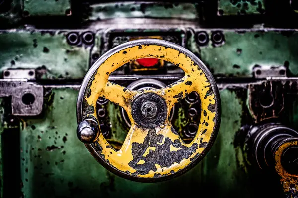 Eski yeşil yıpranmış değirmen kontrol düğmeleri ve kontrol kadranları bir atölyede